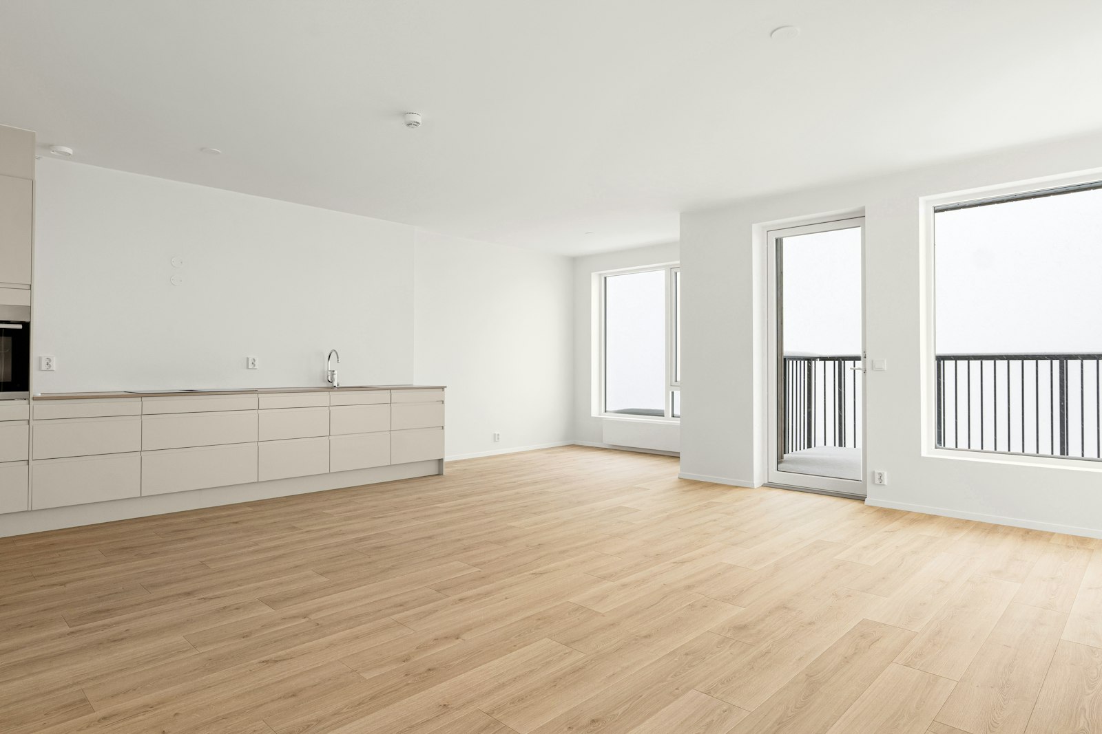 Appartement rénové et vide, parquet clair et cuisine blanche